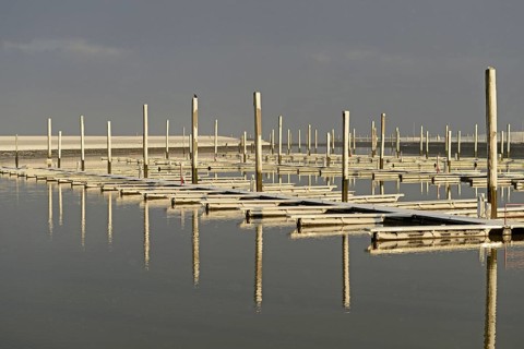 Winter day, onset of winter, morning sun shining on the snow-covered jetties in the marina, North