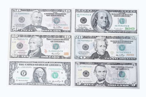 Various US dollar notes on white background, 1 dollar, 5 dollars, 10 dollars, 20 dollars, 50