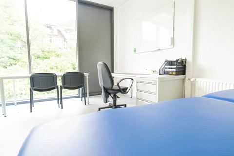 Bright office space with desk and chairs in front of large windows, Care Connect, vaccination kiosk