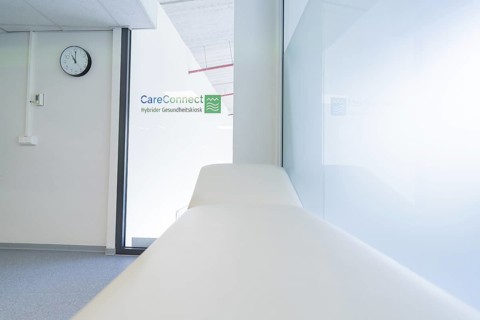 Practice room with couch and glass wall in a bright, modern style, Care Connect, vaccination kiosk