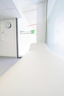 Treatment room with couch and CareConnect logo in minimalist style, Care Connect, vaccination kiosk