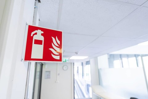Safety sign for fire extinguisher installed in an office corridor, Care Connect, vaccination kiosk