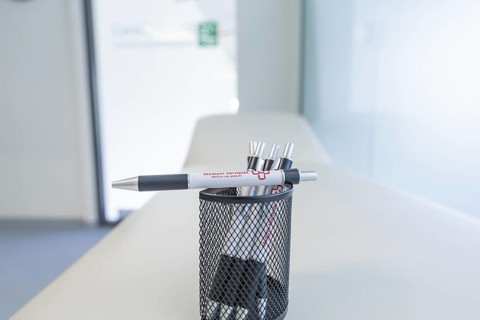 Pen holder with pens on a desk in a modern office, Care Connect, vaccination kiosk for refugees,