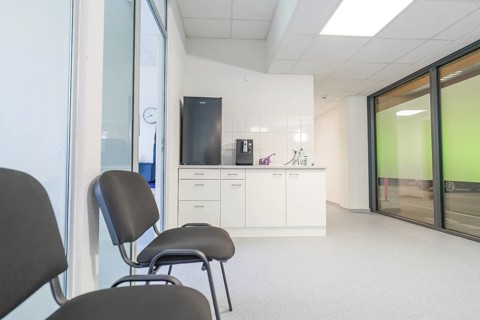A modern waiting room with chairs and large windows, Care Connect, vaccination kiosk for refugees,
