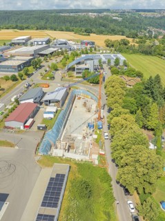 Crane near a construction site with surrounding greenery and buildings, car park construction,