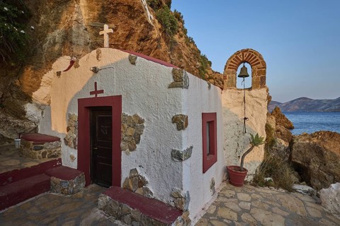 Legend, crab, shell fisherman, coastal chapel with arch and bell, surrounded by rocks and seascape,