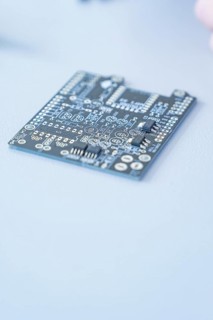 Close-up of a printed circuit board on a blue background with visible circuits