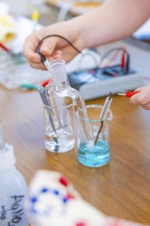 Chemistry experiment with liquids and electrodes on a table, Battery Research, Nagold, Germany