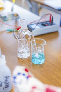Chemical laboratory with beakers containing a clear and a blue liquid, Battery Research, Nagold,
