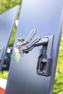 A bunch of keys hanging from a lock on a black background in a close-up, installation of a charging