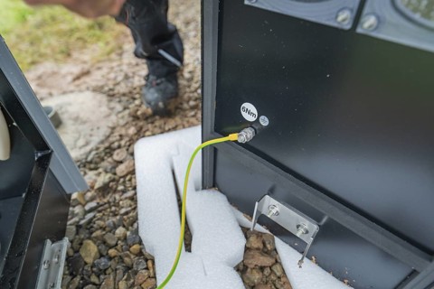 Close-up of an electrical connection with a yellow cable and spanner, assembly of a charging