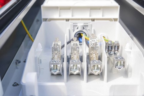 Interior view of a fuse box with various connections and cables, installation of a charging station