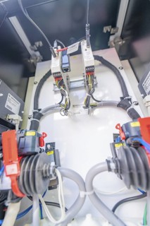 Close-up of the wiring and devices inside an electrical enclosure, assembly of a charging station