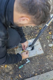 Man working on an outdoor cable installation, assembly of a charging station for electric cars,