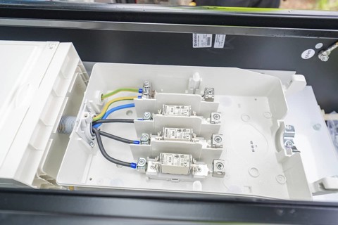 Interior view of a switch box with organised cables and fuses, installation of a charging station