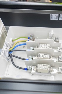 Close-up of an electrical switch box with built-in fuses and cables, installation of a charging