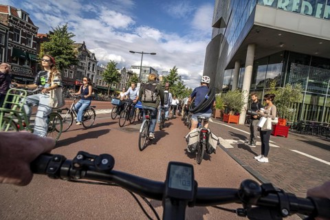 Ride your bike on the central cycle path on Lange Viestraat, Vredenburg, in the city centre of