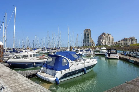 Recreational motorboats and sailing boats moored in marina of fishing village and seaside resort