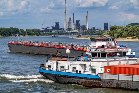 Industrial backdrop of the ThyssenKrupp Steel steelworks in Duisburg-Bruckhausen, cargo ships on