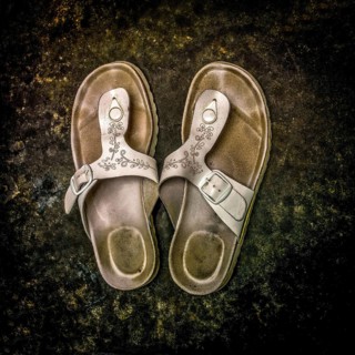 Worn sandals resting on a textured surface showcasing rustic charm and everyday wear in a casual