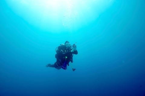 A diver floats alone during a safety stop in the blue depths of the Mediterranean Sea near Hyères,