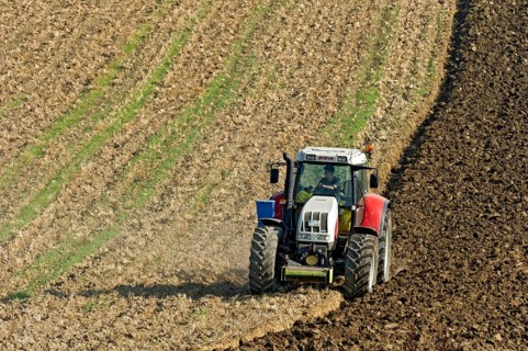 Harvested grain field being turned into a field by Steyr tractor with plough, Hohenpolding, Erding,