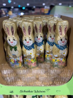 Cardboard chocolate bunnies in retail, empty spaces in the front in a plastic batch of sweets,
