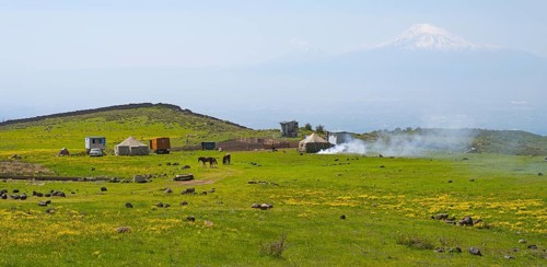 Green meadow with tents and smoke in the foreground, Mount Ararat in the background, nomads, tents