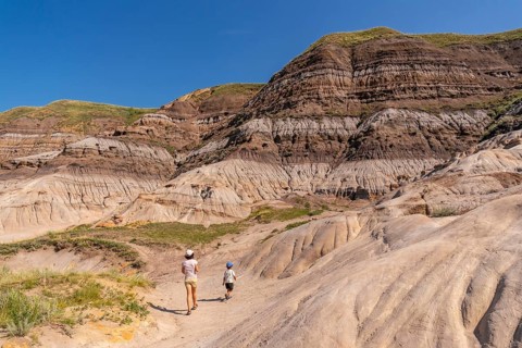 Tourists walking through horseshoe canyon under the bright summer sun, discovering the stunning