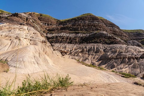 Sunlight illuminates the unique geological formations known as hoodoos, rising from the dry ground