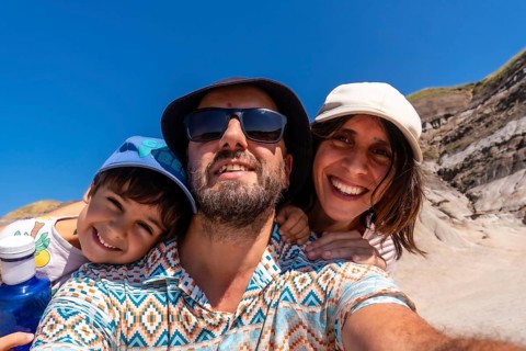 Happy family with a small child taking a selfie portrait with the arid landscape of drumheller,