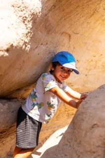Young boy wearing a blue cap and a t shirt is exploring the unique sandstone hoodoo formations in