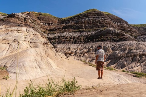 Tourist admiring the landscape of horseshoe canyon in drumheller, alberta, canada, enjoying the