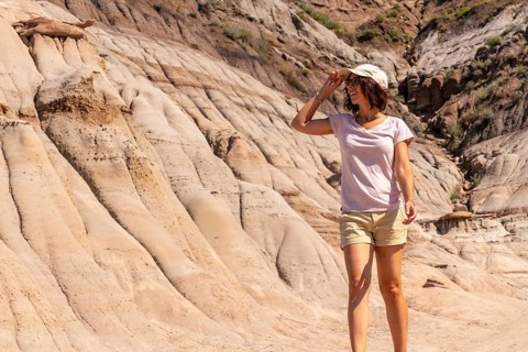 Female tourist shielding her eyes from the sun while exploring the unique hoodoo rock formations in