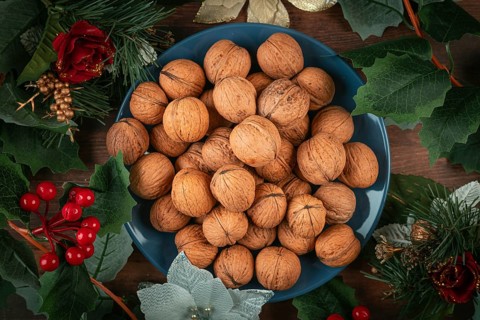 Blue plate with walnuts surrounded by Christmas decoration