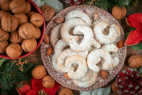 Vanilla croissants on a plate next to walnuts and Christmas decoration