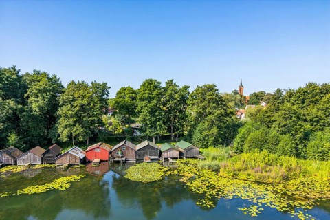 Aerial view, drone photo: house lake with city church and colorful boathouses on stilts, Feldberg,