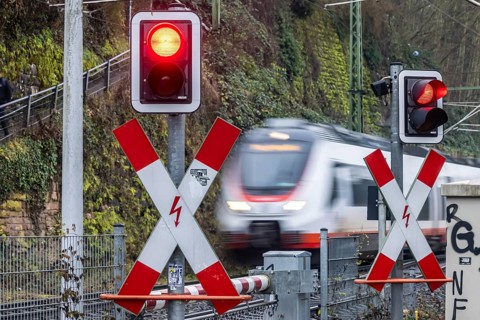 Rail crossing with regional train at Bad Wimpfen station. Flashing light, St. Andrew's Cross and