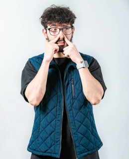 Young man with face of unpleasant odors, covering nose. Person covering nose because bad smells.