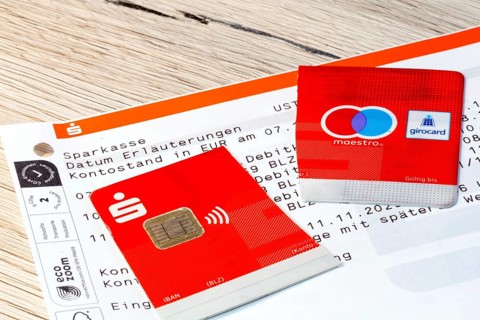 Cut-up savings bank card on account statements (symbolic image)
