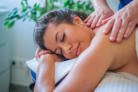 A woman receives a soothing back massage from a professional therapist using oil. The tranquil spa