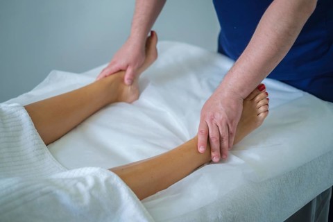 A woman enjoys a soothing calf massage at a spa salon, enhancing her wellness with a skilled