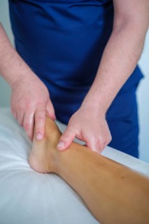 A woman enjoys a soothing foot and leg massage at a spa, where an expert therapist uses oil for