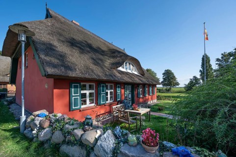 Private house with thatched roof, in front of a captain figure on a bench, Ahrenshoop, DarÃŸ,