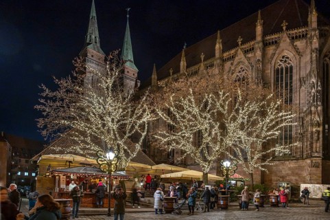 Famous Nuremberg bratwurst house decorated at Christmas time, Sebaldus Church in the back,