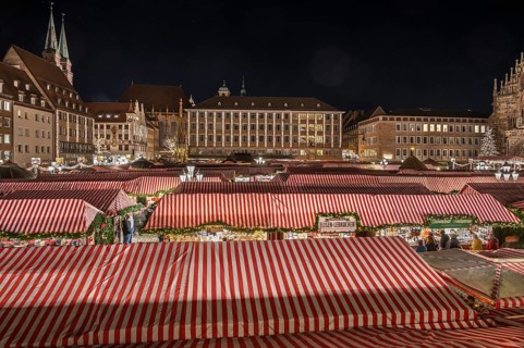 Christmas market illuminated in the evening with the Beautiful Fountain, Town Hall and towers of