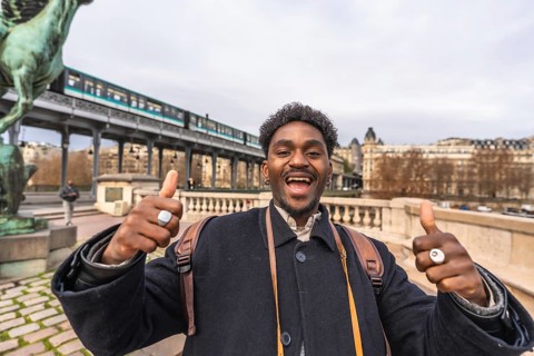 Enthusiastic young black man expressing happiness and positivity with a thumbs up gesture,