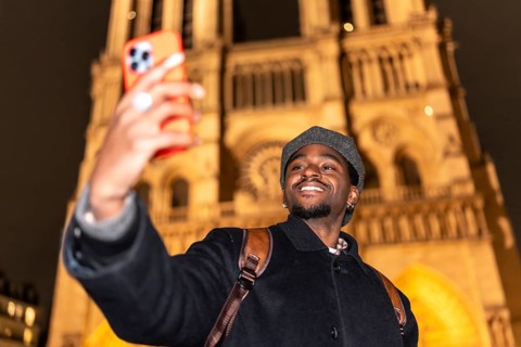 Young man smiling and taking a selfie with a smartphone, capturing a memorable moment during a