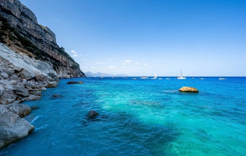 Light blue clear sea on a dream beach on Cala GoloritzÃ©, picturesque rocky coast, cliffs, Golfo di