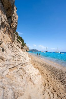 Sandy beach beach and steep cliffs at Cala Luna, Golfo di Orosei, Baunei, Sardinia, Italy